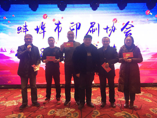 蚌埠市印刷協會副會長、蚌埠市興順彩印廠總經理周興平（中）登臺抽獎，并與獲獎人員合影留念