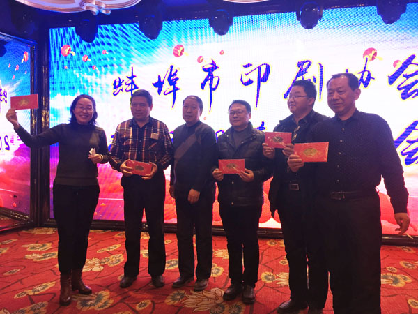 蚌埠市印刷協會副會長、蚌埠市東方彩色印刷廠總經理徐興國（中）登臺抽獎，并與獲獎人員合影留念