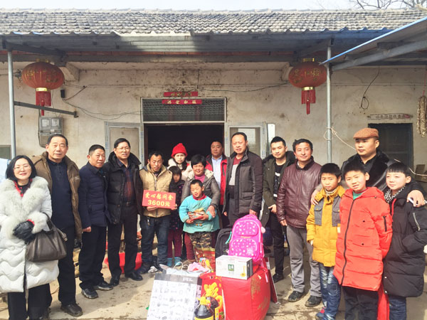 商會愛心慰問團正在張澤家全家（圖中），并與他們合影